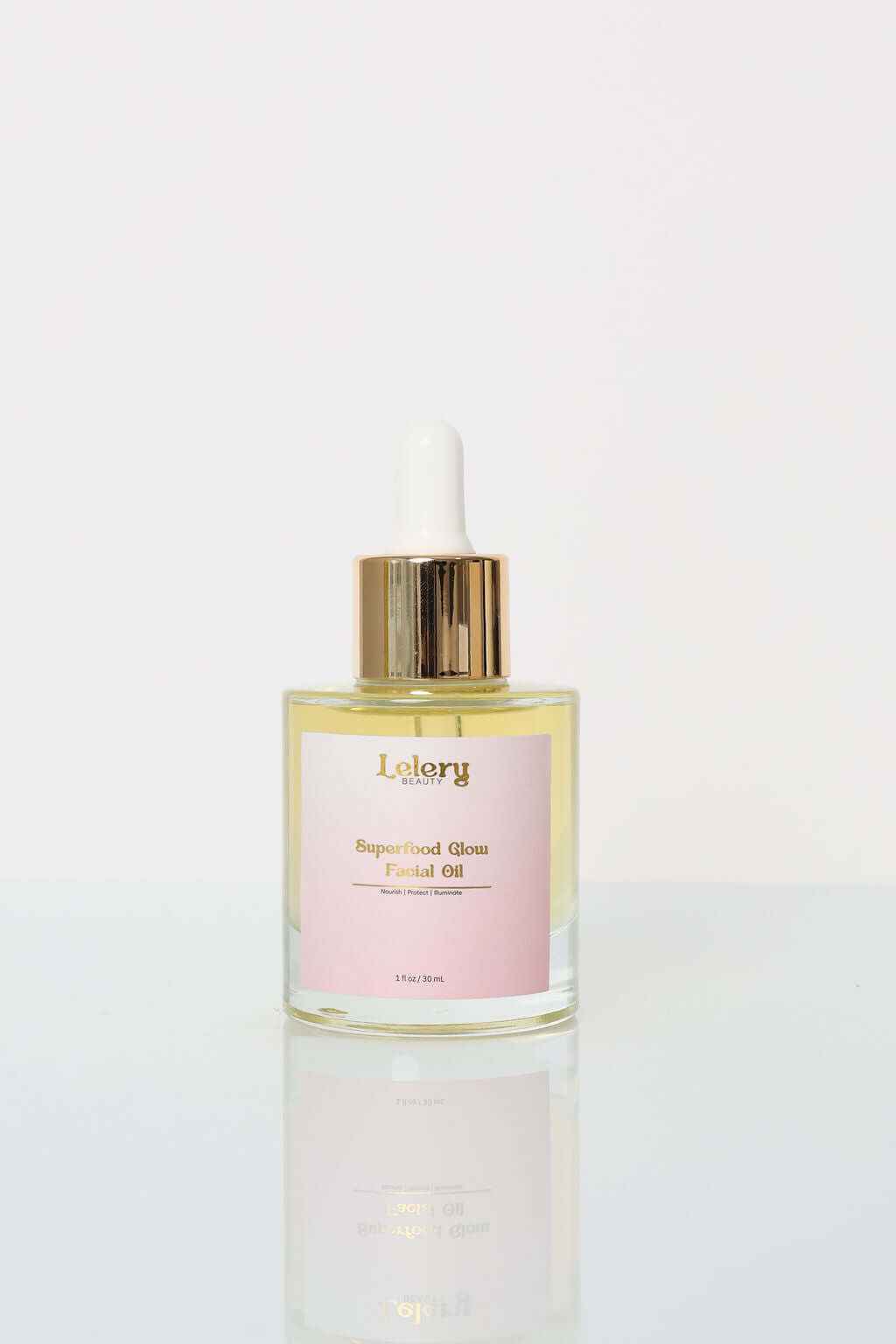 Facial Oil for Glowing Skin - Superfood Glow oil in a glass bottle with dropper on reflective surface.