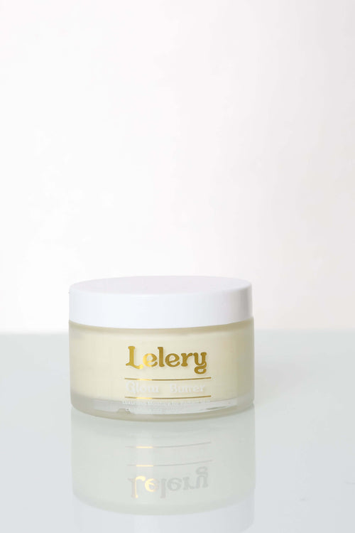 Whipped Body Butter for Glowing Skin in a stylish jar with a gold label on a reflective surface.