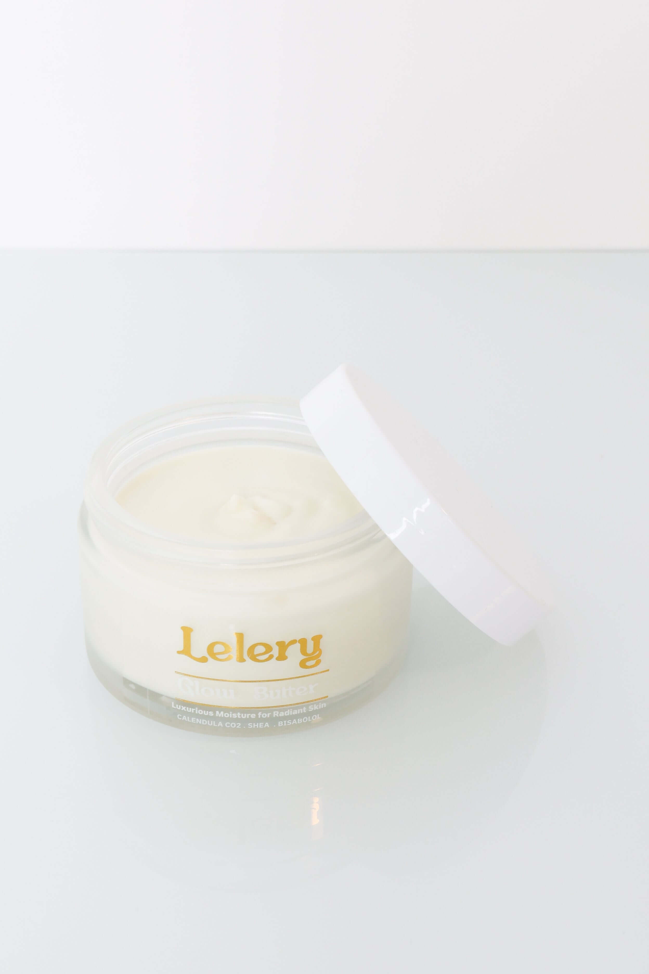 Whipped Body Butter for Glowing Skin in a clear jar with a white lid, promoting deeply hydrating and non-greasy skin.