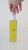 Lelery Glow Body Oil held in hand showing silky radiant skin results.